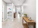 Inviting hallway with neutral paint and tile flooring, leading to bedrooms and dining area at 33716 Elm Hill Br, Wesley Chapel, FL 33545
