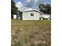 A single-story home's side exterior shows neutral colors with a well-kept lawn, offering a clean and inviting appearance at 3612 Devonshire Dr, Holiday, FL 34691