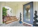 Inviting front porch featuring decorative tiling, an accent tree, and a relaxing porch swing at 4115 N Blvd, Tampa, FL 33603
