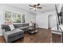 Inviting living room with hardwood floors, a stylish gray sectional, and ample natural light from a large window at 4531 7Th N Ave, St Petersburg, FL 33713