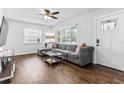 Bright living room featuring hardwood floors, a comfortable gray sectional sofa, and natural light from a large window at 4531 7Th N Ave, St Petersburg, FL 33713