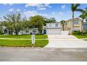 Two-story home with a large driveway, mailbox, and attached two-car garage in daylight at 5005 W Evelyn Dr, Tampa, FL 33609