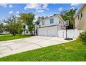 Daytime view of a two-story home featuring an attached two-car garage and a basketball hoop at 5005 W Evelyn Dr, Tampa, FL 33609