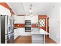 Bright kitchen with white cabinets, stainless steel appliances, marble countertops, and modern pendant lighting at 509 Falmouth St, Temple Terrace, FL 33617
