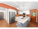 Bright kitchen featuring white cabinets, stainless steel appliances, a marble island, and a rustic door at 509 Falmouth St, Temple Terrace, FL 33617