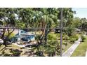 Exterior view of the house with a beautiful green lawn, sidewalk, and mature trees at 5680 77Th N Ave, Pinellas Park, FL 33781