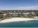 An aerial view of the condo buildings, beach and ocean with cityscape in the background at 5701 Bahia Del Mar Cir # 108, St Petersburg, FL 33715