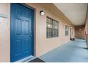 Exterior shot featuring a blue unit door and window with neutral tan stucco siding at 6100 Gulfport S Blvd # 415, Gulfport, FL 33707