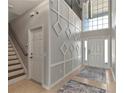 Open foyer with a staircase, high ceiling, decorative wall trim, and tile flooring at 7732 Bulls Head Dr, Wesley Chapel, FL 33545