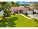 Beautiful single-story home with a well-maintained lawn, stone accents, and an attached two-car garage at 7818 Holiday Dr, Spring Hill, FL 34606