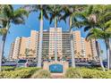Beautiful exterior of the Regatta Beach Club with palm trees, manicured landscaping and private parking at 880 Mandalay Ave # N607, Clearwater Beach, FL 33767