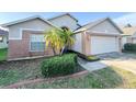 Charming single-story home featuring a two-car garage, brick accents, and a well-maintained front yard at 9735 Riverchase Dr, New Port Richey, FL 34655