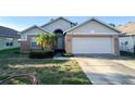 Charming single-story home featuring a two-car garage, brick accents, and a well-maintained front yard at 9735 Riverchase Dr, New Port Richey, FL 34655