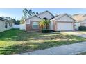 Charming single-story home featuring a two-car garage, brick accents, and a well-maintained front yard at 9735 Riverchase Dr, New Port Richey, FL 34655