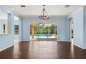 Bright living room with hardwood floors, chandelier and sliding glass doors leading to a screened in pool at 10205 Deercliff Dr, Tampa, FL 33647