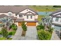 Aerial view of the townhome showcasing lush landscaping, water views and two-car garage at 11291 Cay Spruce Way, San Antonio, FL 33576