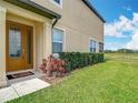 Charming front door with decorative glass, surrounded by lush greenery and manicured lawn at 11291 Cay Spruce Way, San Antonio, FL 33576