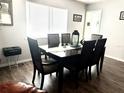 Inviting dining room featuring a spacious table with seating for six, wood floors and natural light at 11807 Addison St, Spring Hill, FL 34609