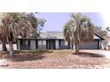 Inviting single-story home with a cozy front porch, palm trees, and an attached garage, offering curb appeal at 11807 Addison St, Spring Hill, FL 34609