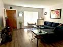 Comfortable living room featuring a large window, dark sectional couch, and wood flooring at 11807 Addison St, Spring Hill, FL 34609