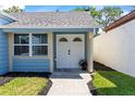 Inviting entryway with double doors, decorative window, and well-maintained landscaping at 12516 Cobble Stone Dr, Hudson, FL 34667