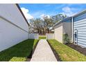 Landscaped walkway between homes leads to a well-maintained yard and charming neighborhood at 12516 Cobble Stone Dr, Hudson, FL 34667