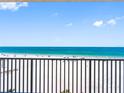 Balcony view of the pristine beach with clear blue water, white sand, and beachgoers at 13500 Gulf Blvd # 506, Madeira Beach, FL 33708