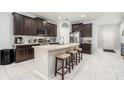 This stunning kitchen features a center island, dark cabinets, and white subway tile backsplash at 15561 Stone House Dr, Brooksville, FL 34604