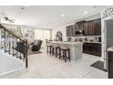 A modern kitchen with dark cabinets, a center island with seating, and stainless steel appliances at 15561 Stone House Dr, Brooksville, FL 34604