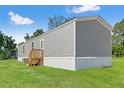 Side view of a gray home with green lawn on a beautiful sunny day at 16070 La Bella St, Brooksville, FL 34604