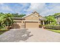 Charming one-story home featuring a three-car garage, brick paved driveway, and beautiful landscaping at 19312 Sunset Bay Dr, Land O Lakes, FL 34638