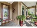 Inviting covered front porch with tile flooring, a decorative door, and outdoor seating area at 19312 Sunset Bay Dr, Land O Lakes, FL 34638