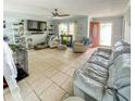 Spacious living room with tile floors, comfortable seating, a ceiling fan, and direct access to the outside at 22443 Crows Nest Ct, Lutz, FL 33549