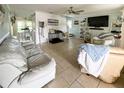 Light-filled living room with tile flooring, comfortable seating, ceiling fan, and access to the backyard at 22443 Crows Nest Ct, Lutz, FL 33549