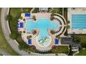 Birds eye view of clubhouse pools featuring umbrellas, lounge chairs, and splash pad at 22489 Storybook Cabin Way, Land O Lakes, FL 34637
