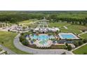 Aerial view of community clubhouse and pool area with lap pool, splash pad, and seating at 22489 Storybook Cabin Way, Land O Lakes, FL 34637