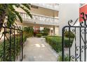 View of a courtyard with lush plants framed by a black metal gate at 2630 Pearce Dr # 108, Clearwater, FL 33764