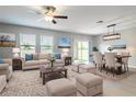 Bright living and dining area with neutral decor, large windows, and sliding glass door access to yard at 35100 Brackett Bnd, Zephyrhills, FL 33541