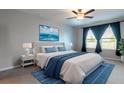 Comfortable bedroom featuring a large bed, ceiling fan, cool colors, and natural light at 35100 Brackett Bnd, Zephyrhills, FL 33541
