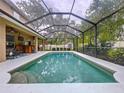 Sparkling in-ground pool with a screened enclosure and view of the fenced-in backyard at 3544 Brook Crossing Dr, Brandon, FL 33511