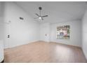 Bright and airy living room with high ceilings, light wood floors, and large window at 3705 Simpson Ct, Palm Harbor, FL 34684