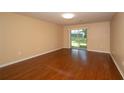 Bright living room with wood flooring and sliding glass doors providing natural light and outdoor views at 37712 Aaralyn Rd, Zephyrhills, FL 33542