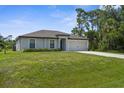 Inviting single-Gathering home featuring green lawn, neutral stucco and attached garage at 4831 Hillman Ter, North Port, FL 34288