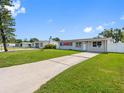 Wide angle view of charming home with a long driveway and green lawn on a sunny day at 4925 Murray Hill Dr, Tampa, FL 33615