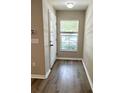 Inviting entryway featuring wood-look flooring, neutral paint, and natural light from a window, creating a welcoming space at 6333 Maisie Rd, Zephyrhills, FL 33542