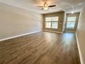 Spacious living room features wood-look floors, neutral walls, bright light, and ceiling fan at 6333 Maisie Rd, Zephyrhills, FL 33542
