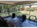 Relaxing screened-in patio with comfortable seating and view of the backyard at 7317 Mitchell Ranch Rd, New Port Richey, FL 34655