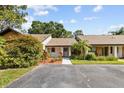 The single story home has a brown roof, a small front yard, and lots of trees at 7633 Piping Rock Ct # 7633, New Port Richey, FL 34654