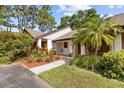 The single story home has a brown roof, a small front yard, and lots of trees at 7633 Piping Rock Ct # 7633, New Port Richey, FL 34654