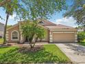 Well-maintained home featuring a two-car garage, landscaped yard, and decorative windows at 8124 Brinegar Cir, Tampa, FL 33647